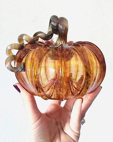 hand holding a luke adams glass pumpkin harvest